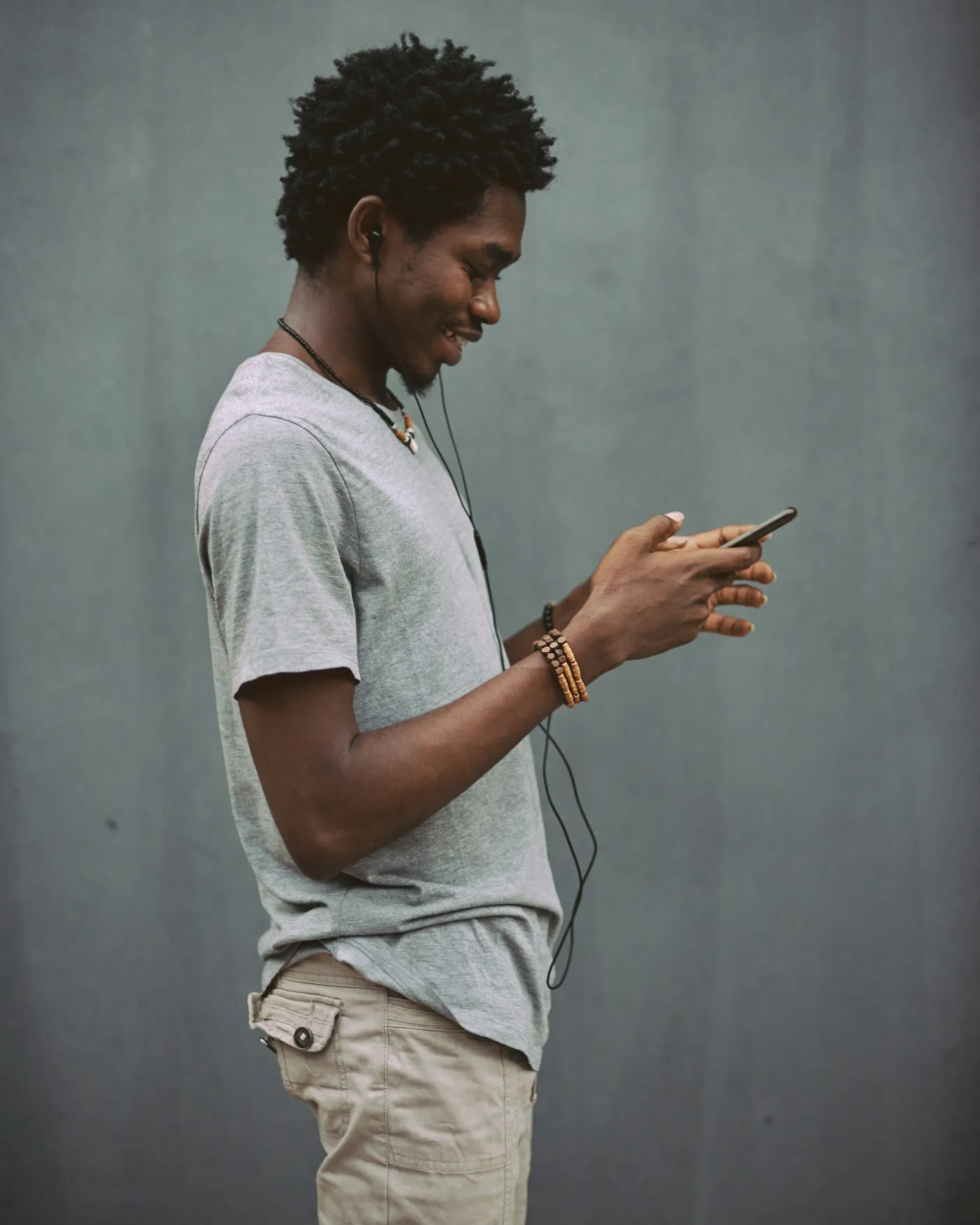 A young man smiling at his phone
